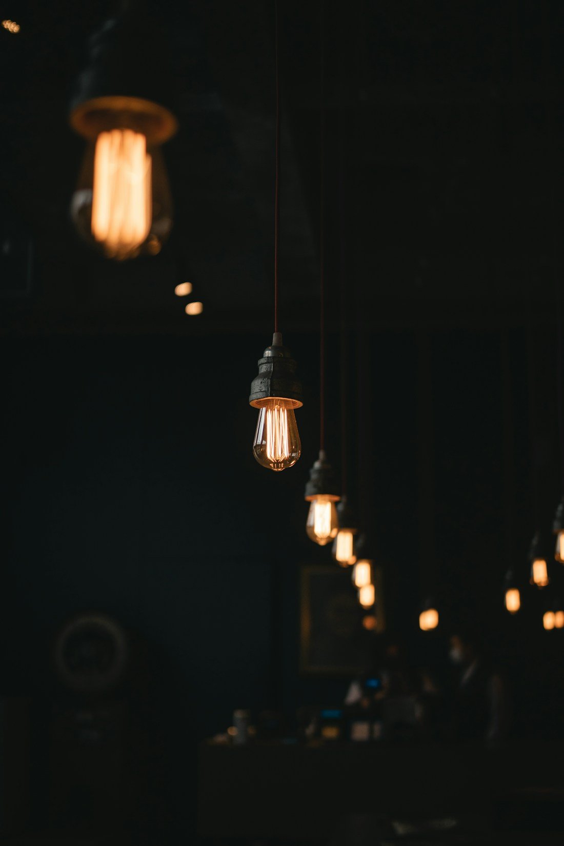 Warm illuminated pendant bulbs in a dark interior